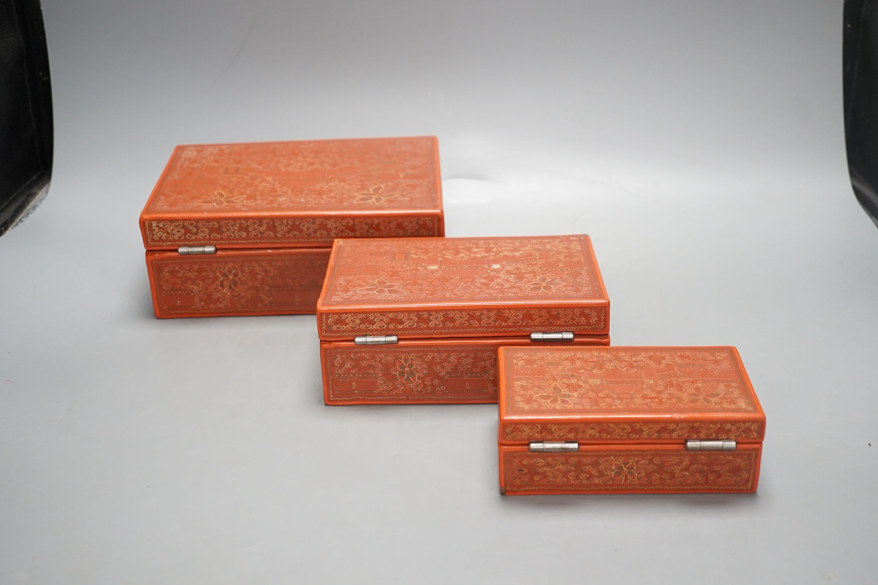 Three Burmese red lacquer graduated boxes, largest 21 cms wide.